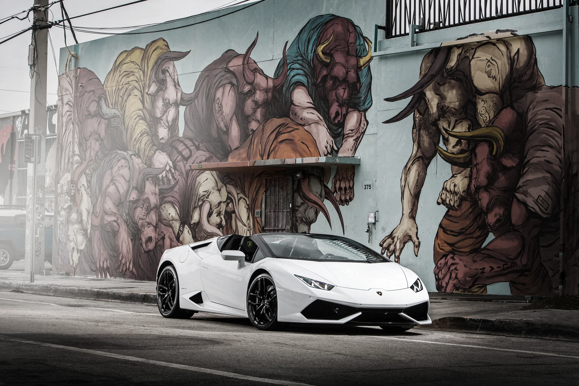 White Lamborghini photographed against a Calgary street mural, from AVA’s current website